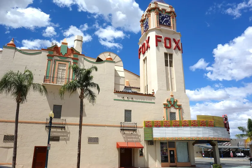 The Fox Theater's clock tower and red FOX letters above its marquee on a sunny day in downtown Bakersfield