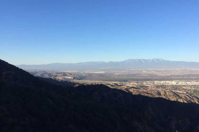 Looking out from the hills above Corona across the Inland Empire valley to a distant mountain range under a clear sky