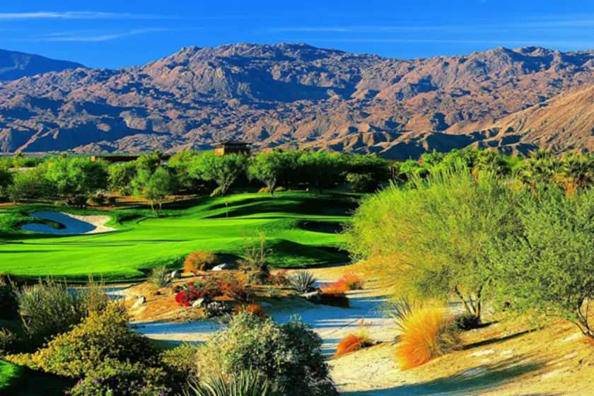 A green fairway and desert plantings below rugged mountains on the Mountain View course at Desert Willow in Palm Desert