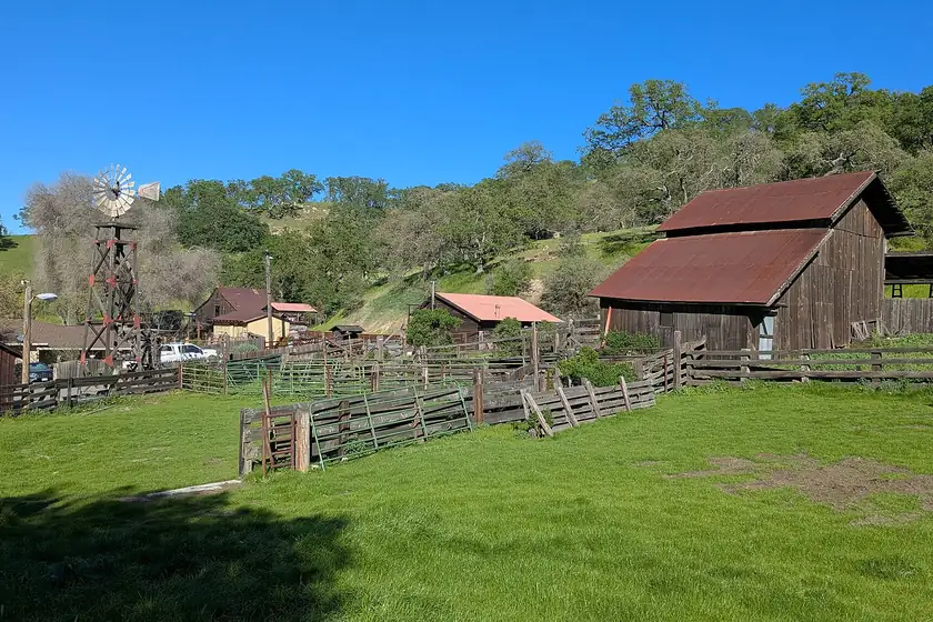 The red barn, windmill and corrals of historic Borges Ranch below oak-covered hills in Walnut Creek